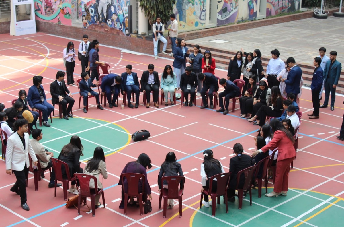Students seated in a circle discussing an economics scenario